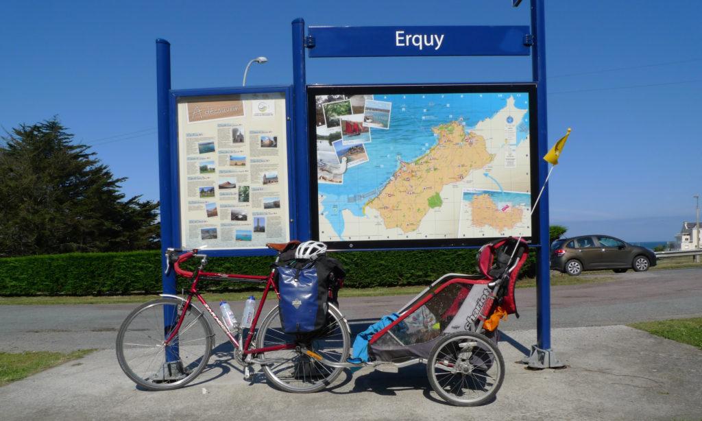 Bike touring bike with Thule Chariot bike trailer parked in front of map in Erquy, Brittany.